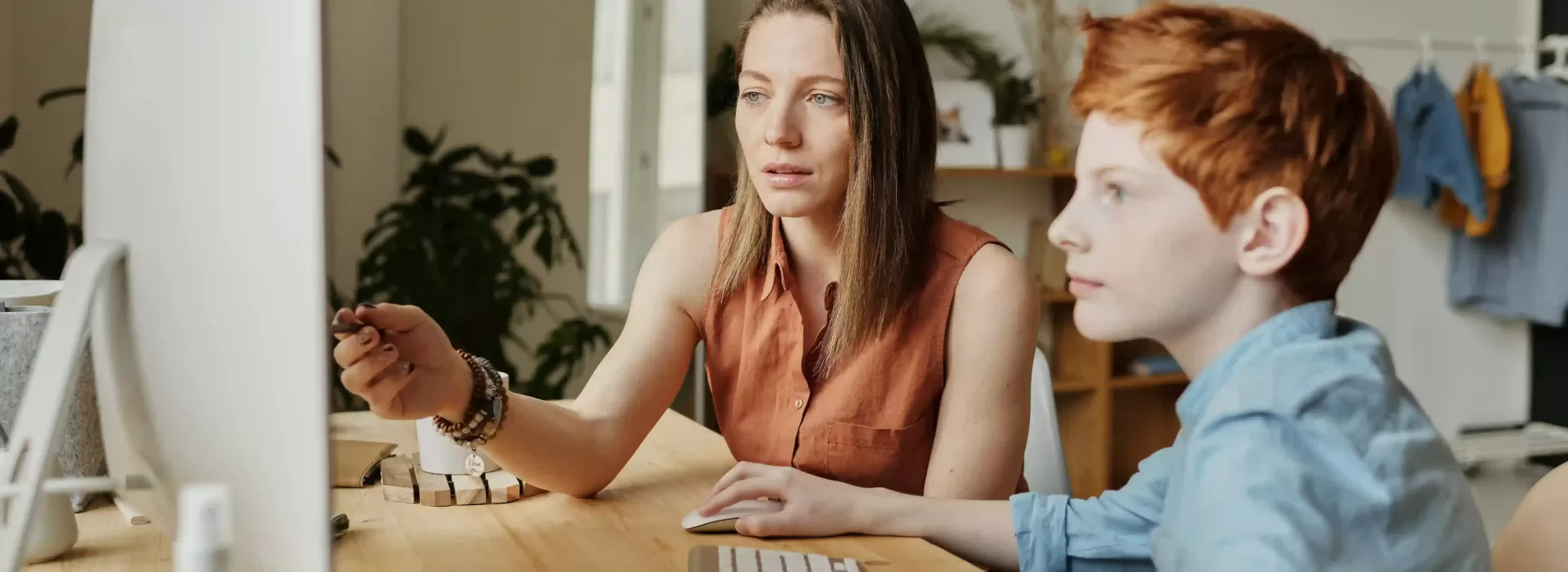 Women and boy sat at a desk on a computer